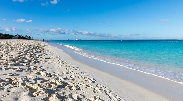 Avión de Aerolíneas Argentinas en la pista con playa caribeña de fondo