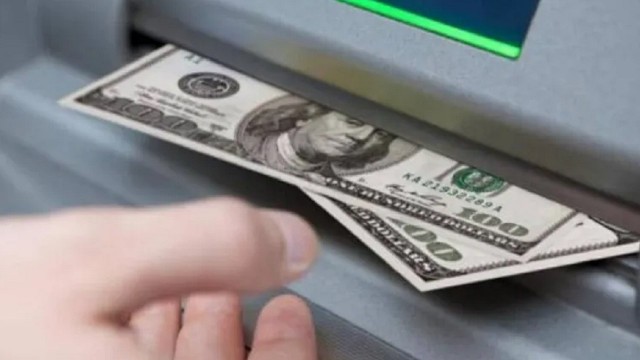 Tarjeta de crédito siendo insertada en un cajero automático en el exterior