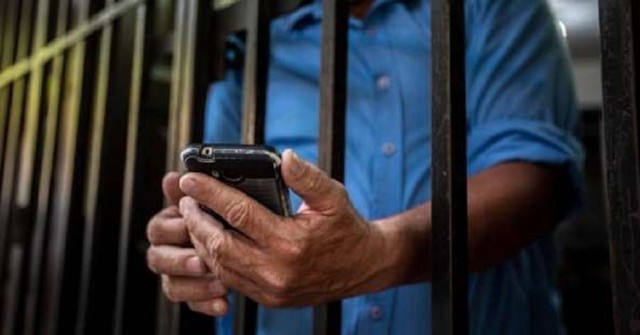 Ilustración de un teléfono celular con un símbolo de prohibición frente a una reja.