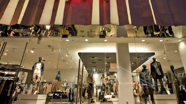 Fachada de una tienda H&M en el exterior, con maniquíes en vidriera.