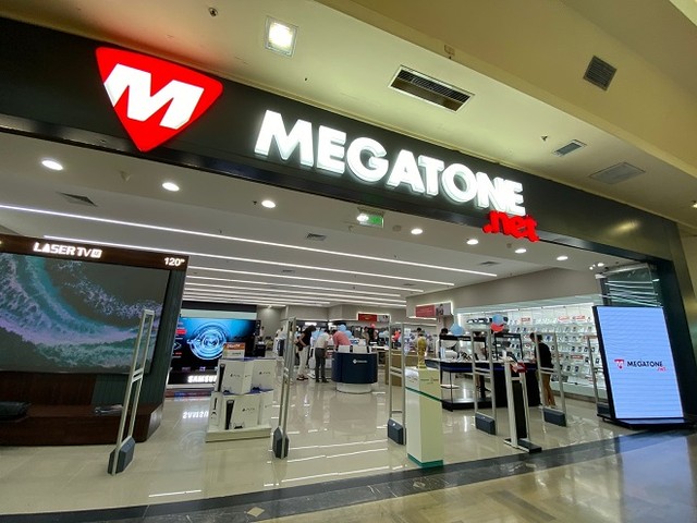 Fachada de un local comercial de electrodomésticos con las persianas bajadas.