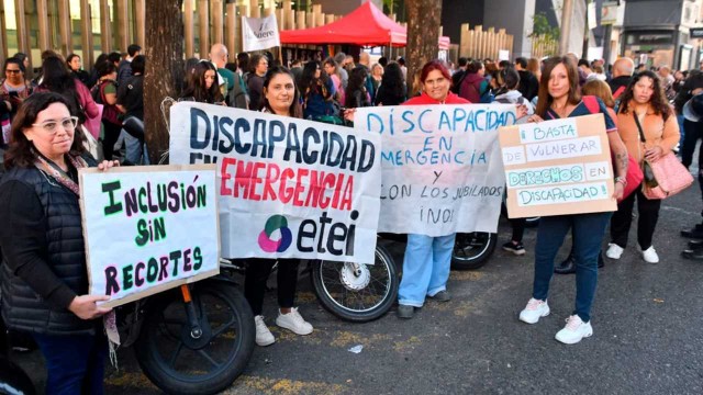 Persona con discapacidad en silla de ruedas frente a un edificio gubernamental