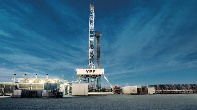 Infografía o vista aérea de instalaciones de YPF en el yacimiento Vaca Muerta, con gráficos de producción.