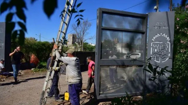 Portón de chapa reforzada cerrando una calle residencial en Villa Allende, Córdoba.
