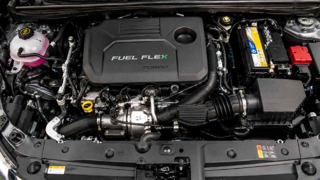 Motor flex fuel en un vehículo moderno, con surtidores de etanol y nafta de fondo