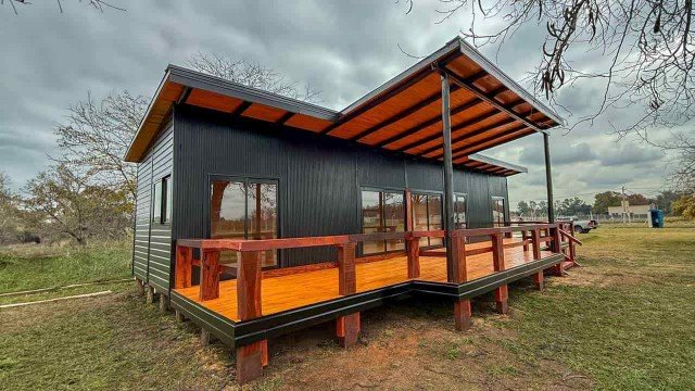 Cabaña prefabricada de madera modelo Soleil con galería y ventanales