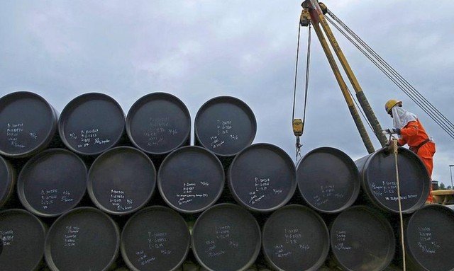 Gráfico de cotización del petróleo Brent y WTI en baja, con barriles y banderas de Estados Unidos e Irán