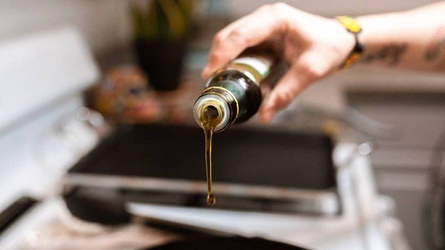 Alimentos naturales como lentejas, avena, huevo, aceite de oliva y almendras sobre una mesa de madera