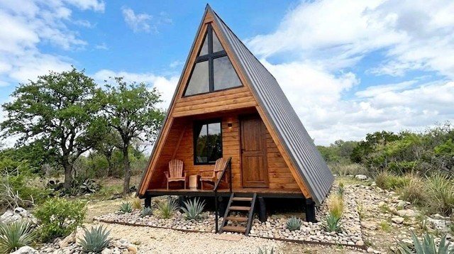 Cabaña alpina de madera de 25 metros cuadrados con diseño alpino, ventanales de aluminio y estructura sobre pilotes