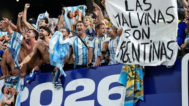 Jugadores de la Selección argentina sosteniendo una bandera blanca con la inscripción 'Las Malvinas son argentinas' durante los festejos tras el partido contra Inglaterra en el Mundial 2026