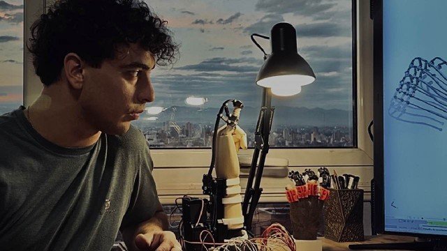 Máximo Salzmann trabajando en un exoesqueleto de mano en su taller