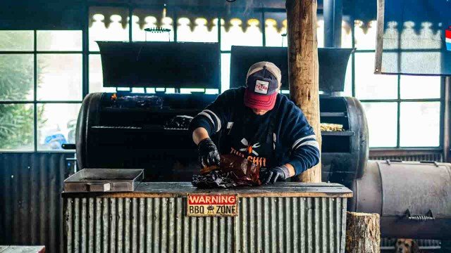 Interior de Texas BBQ con ambientación de rancho texano y parrilla de ahumado